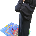 Person wearing a black abaya on a colorful prayer mat with Arabic text