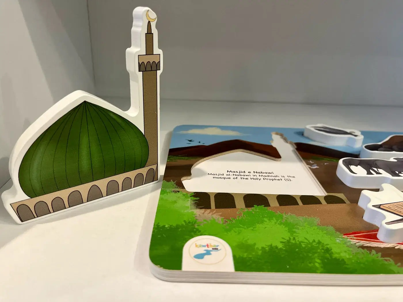 Educational toy puzzle by Kawthar kids with a mosque model and a book on a white surface