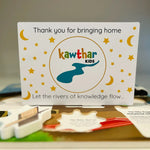 Card with 'Kawthar Kids' branding on a table with educational materials.