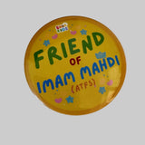 A round yellow button badge with colorful text reading 'FRIEND OF IMAM MAHDI (ATFS)' and a small 'SHIA KIDS' logo, photographed on a white surface.