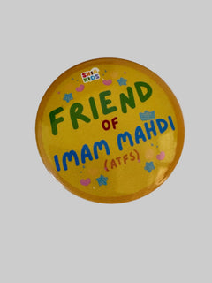A round yellow button badge with colorful text reading 'FRIEND OF IMAM MAHDI (ATFS)' and a small 'SHIA KIDS' logo, photographed on a white surface.
