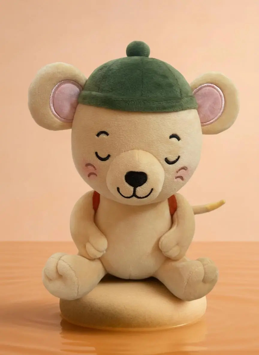 A cute plush toy of a sleeping cartoon mouse wearing a green cap, sitting on a round base against a warm peach background.