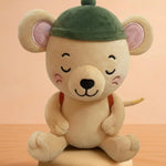 A cute plush toy of a sleeping cartoon mouse wearing a green cap, sitting on a round base against a warm peach background.