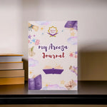 Journal with colorful design and 'my Areeza Journal' text on a shelf.