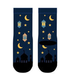 A pair of dark navy blue socks with a festive Ramadan night print, featuring yellow crescent moons, stars, lanterns, and mosque silhouettes, displayed on a solid white background.