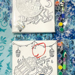 Canvas with illustrations and coloring supplies on a blue patterned background