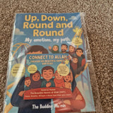 Children's book titled 'Up, Down, Round and Round' on a carpeted floor.