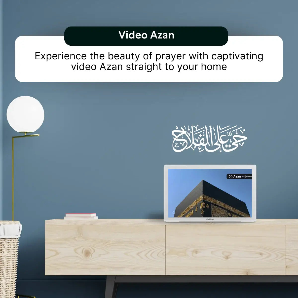 Laptop on a wooden cabinet with a screen displaying video Shia Azan against a blue wall.
