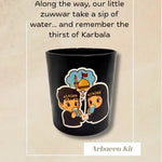Black mug with child characters drinking from a cup and remembering Karbala and text on a beige background, featuring the brand 'ABABEL'.