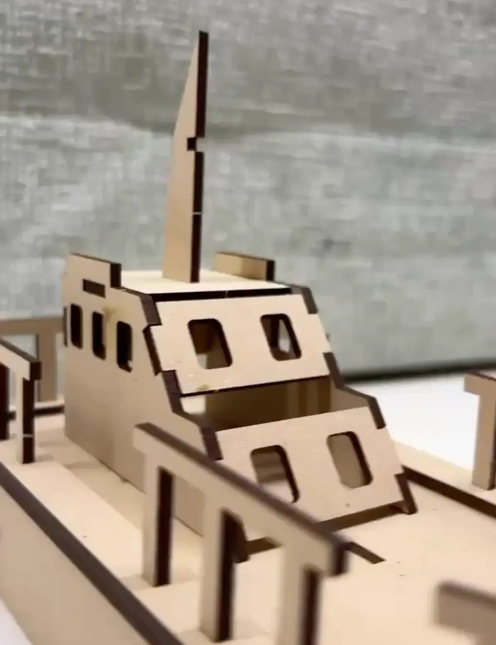 Wooden model of a ship on a reflective surface with a blurred background