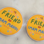 Two round badges with the text 'FRIEND OF IMAM MAHDI (ATFS)' written on them, placed on a marble surface.