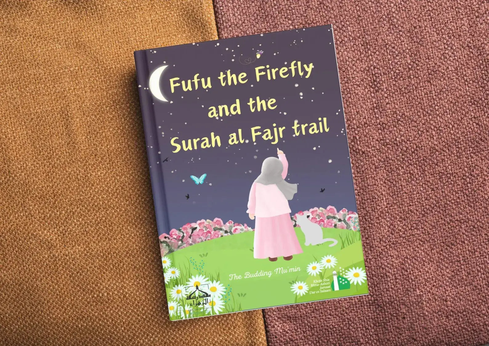 Book titled 'Fufu the Firefly and the Surah al.Fajr trail' on a textured surface by The Budding Mu'min Shia Kids Children Story Book