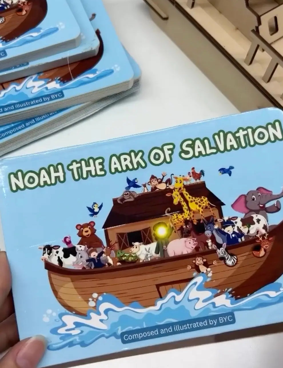 Children's book titled 'Noah the Ark of Salvation' with a wooden ark model on a white surface.