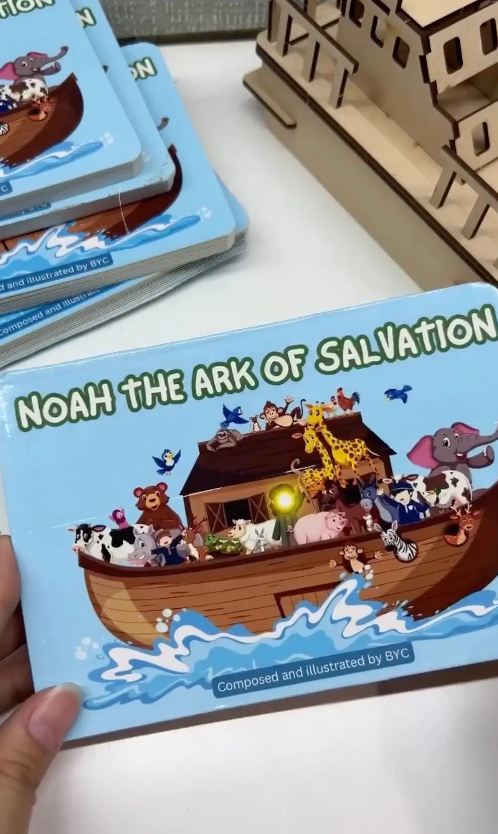 Children's book titled 'Noah the Ark of Salvation' with a wooden ark model on a white surface.