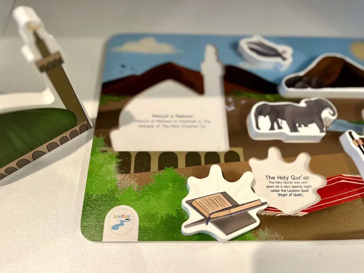 Educational children's puzzle for Shia Muslim Kids with cut-out pieces and illustrations on a flat surface