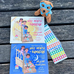 Two books titled 'Mysteries in the Holy Month of Ramadan' with a plush toy and colorful paper on a wooden surface.