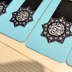 Decorative items with "Ya Qaim Aale Muhammad" calligraphy on a light blue background